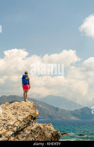 Donna celebrando o pregando in belle montagne ispiratrice sunrise. ragazza escursionista sulla cima della montagna escursioni o scalate. cercando e godendo di ispirazione Foto Stock
