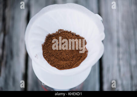 Caffè macinato fresco nel versare il gocciolatore, in procinto di essere prodotta in un delizioso caffè Foto Stock