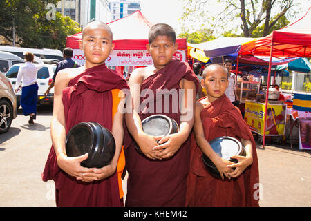 Yangon, myanmar-Marzo 3, 2017: tre unidentified giovane debuttante monaci mattina a piedi alms a Yangon, Myanmar il 3 marzo 2017. Foto Stock