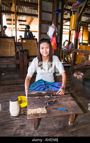 Inle, myanmar - 4 marzo 2017: giovane donna birmana rendendo thread dal fiore di loto in un villaggio galleggiante al Lago Inle il 4 marzo, 2017, Myanmar (Birmania) Foto Stock