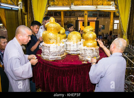 Inle, myanmar- Marzo 4, 2017:myanmar la gente a prendere il Golden Leaf per le cinque piccole immagini di buddha tutti rivestiti di oro a phaung daw oo pagoda in lak inle Foto Stock