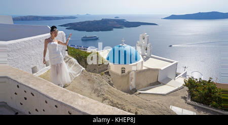 Bridal ponendo in corrispondenza di un punto di vista con la chiesa ortodossa, villaggio firofestani, isola di Santorini, Cicladi, Egeo, Grecia Foto Stock