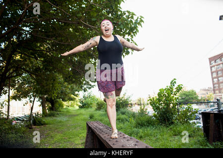 Una giovane donna in equilibrio su un banco di lavoro Foto Stock