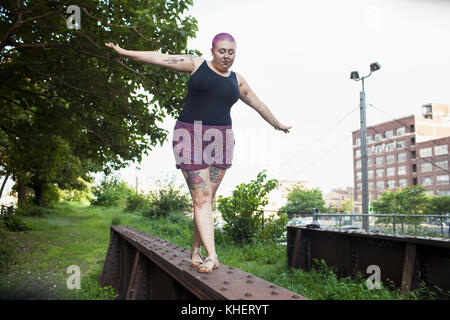 Una giovane donna in equilibrio su un banco di lavoro Foto Stock