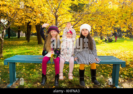 Autunno ritratto di bellissimi bambini sul banco di lavoro. Felice bambine con foglie nel parco in autunno. Foto Stock