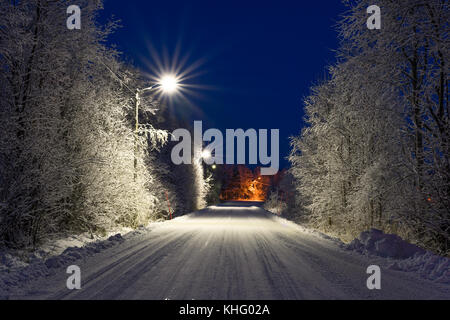 Piccola strada d'inverno in Alta Finnmark, Norvegia. Alberi coperti di neve. Foto Stock