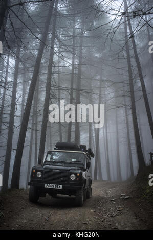 Land Rover Defender ad esplorare le Alpi vicino a Sauze d'Oulx. Viaggiando tra Str. dell' Assietta e Sauze d'Oulx strada alpina di spazio negativo foto Foto Stock