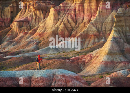 Una persona a scattare foto in strisce colorate canyon mongolo tsagaan suvarga. fotografo prende la foto di un luminoso bellissimo canyon. Foto Stock