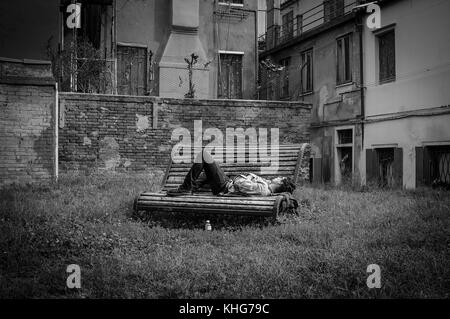 Dormire su una panchina in Venezia, hanno un pomeriggio snooz nei vicoli di Venezia, lo spazio verde con questa città giardino circondato da edifici Foto Stock