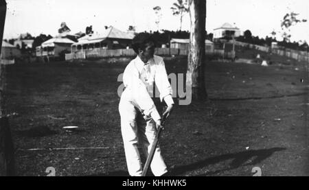 Questa fotografia cattura una partita di cricket a Norman Park, Brisbane, intorno all'anno 1900. L'immagine mostra i giocatori impegnati nel gioco, tipico degli sport ricreativi all'inizio del XX secolo, fornendo uno sguardo sulle attività sociali e atletiche di quel tempo. Foto Stock
