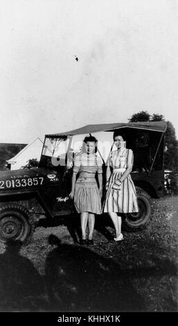 Questa fotografia del 1944 mostra due giovani donne in piedi di fronte a una Jeep dell'American Air Transport Command a Brisbane. Cattura un momento durante la seconda guerra mondiale, quando la città servì come importante base militare. Foto Stock