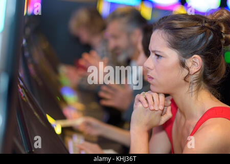 Bella donna in abito rosso Gioca slot machine Foto Stock