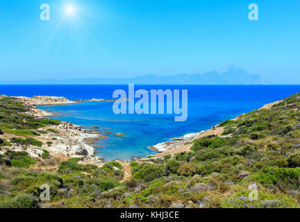 Estate sunshiny stony Sea coast paesaggio con monte Athos visualizza nel lontano (halkidiki, Sithonia, Grecia). Foto Stock