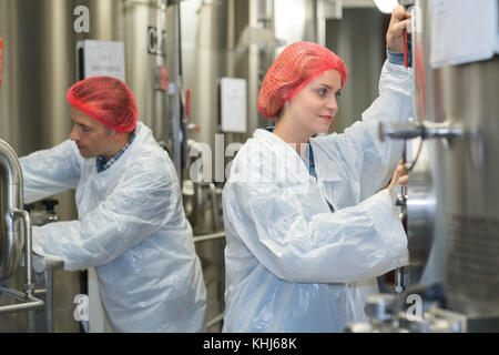 Uomo e donna che lavorano su tini Foto Stock