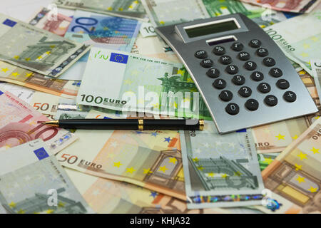 Calcolatrice e soldi si trovano sullo sfondo di euro. Idee e concetti di business. Close-up Foto Stock