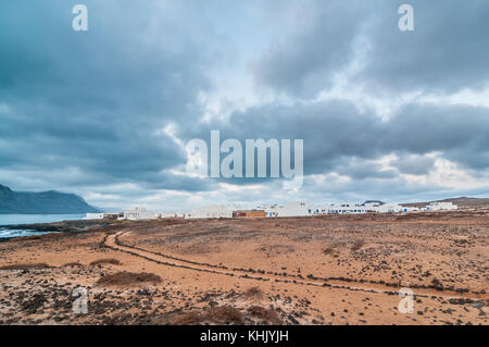 Caleta del Sebo in un giorno nuvoloso con un percorso in primo piano, La Graciosa, Isole Canarie, Spagna Foto Stock