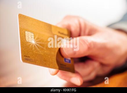 Primo piano di una mano con un golden carta di credito Foto Stock