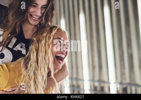 Due ridendo giovani amici divertendosi mentre godendo una notte fuori insieme nella città Foto Stock