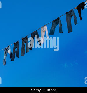 Jeans blu hanging on line con il cielo dietro a Malmo Svezia Foto Stock