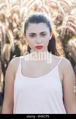 Ritratto di un serio bella giovane donna fissando all'aperto Foto Stock