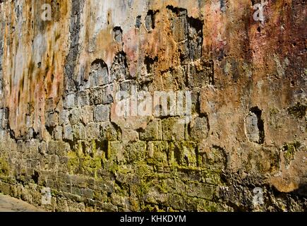 Rosso antico incrinato un muro di mattoni con erba verde pavimento a Chengkan antica città in Cina Foto Stock