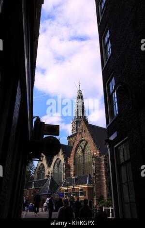 Vista della Oude Kerk ad Amsterdam da un vicolo buio Foto Stock