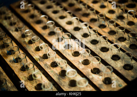 Istruzione secondaria nel Regno Unito: File di provette in vetro in rack in legno vecchio stile in un laboratorio di chimica scientifica Foto Stock