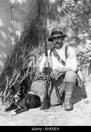 Guardiano di una tenuta nella regione della Camargue in Francia, in posa con un fucile e il suo cane, Francia, 1922. Foto Stock