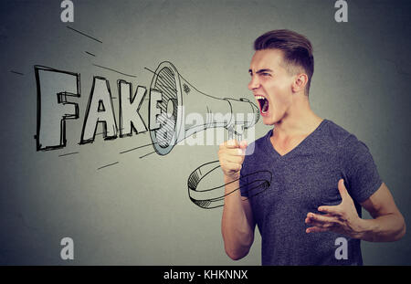 Arrabbiato entusiastico uomo urlando in un megafono diffondere notizie false Foto Stock