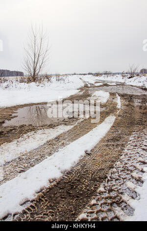 Tracce di battistrada della vettura le ruote sulla campagna coperta di neve road Foto Stock