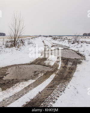 Tracce di battistrada della vettura le ruote sulla campagna coperta di neve road Foto Stock