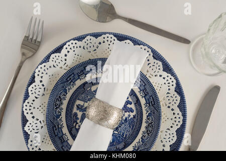 Forcella, Coltello per burro, cucchiaio, igienico e pizzi placemat disposti su sfondo bianco Foto Stock