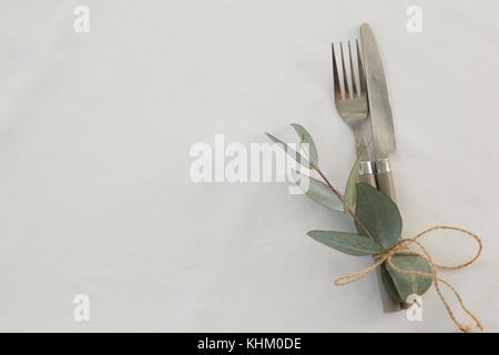 Close-up di forchetta e coltello per burro legato con foglie Foto Stock