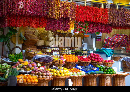 Colorato mercato in stallo con secchi peperoncino e frutti esotici al Mercado dos Lavradores, Funchal, Madeira Foto Stock