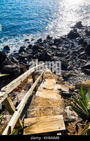 Vecchie scale di legno che conducono a una roccia vulcanica beach a Funchal, Madeira, Portogallo Foto Stock