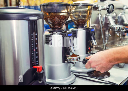 Close up barista prendere caffè macinato in gruppo, preparare per la produzione di birra colpo espresso. Il fuoco selettivo Foto Stock