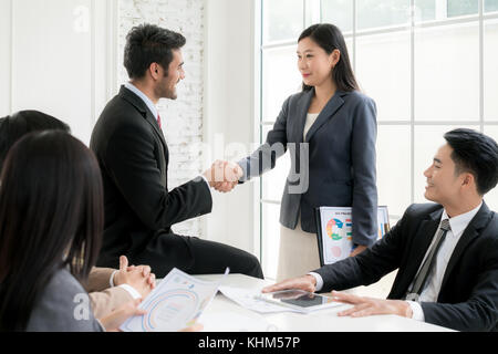 Successo del lavoro asian imprenditore e imprenditrice stringono le mani in sala consiglio al termine di una riunione. Foto Stock