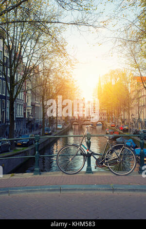 Bicicletta sul ponte con Paesi Bassi case tradizionali e canale di Amsterdam in Amsterdam , Paesi Bassi. Foto Stock