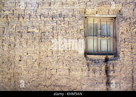 Muro di fango e la piccola finestra di casa Foto Stock