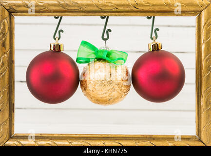 Tre round e lucenti globi di natale appeso sul photo frame come felice vacanze invernali concept Foto Stock