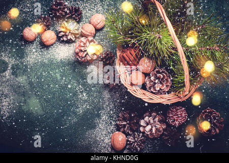 Scheda di Natale. Cestello con coni di abete e rami, noci e cannella. Foto Stock