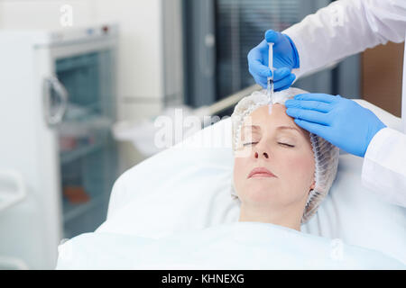 Femmina di invecchiamento avente antirughe iniezione nella sua fronte Foto Stock