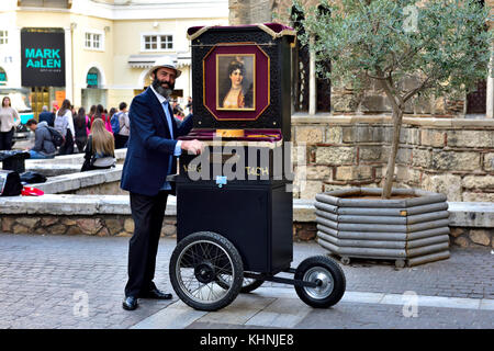 Musicista di strada a giocare una mano canna a gomito pianoforte o lanterna mentre wheeling lungo Ermou Street nel centro di Atene, Grecia. La canna pianoforte fu fi Foto Stock