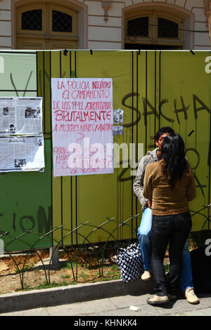 Giovane kissing accanto a un poster che chiedono il motivo per cui la polizia boliviana violentemente invaso la strada TIPNIS marcia di protesta camp a Chaparina vicino a Yucumo, Bolivia Foto Stock