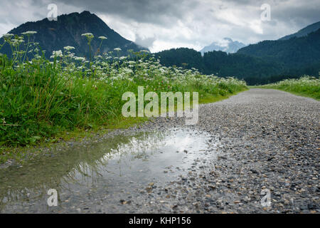 Impasto con acqua a un sentiero in Baviera con nuvole scure Foto Stock