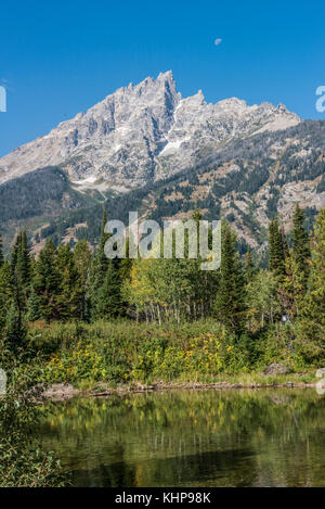 Grand Teton Mountains da Lake Jenny con la luna tramonta dietro il Grand Teton Foto Stock