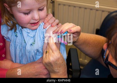 Pratica dando infermiere NHS 4-in-1 pre-scuola / booster Pre scuola & booster MMR seconda dose di immunizzazione inoculazione / / jab a 3 anno di età bambino Foto Stock