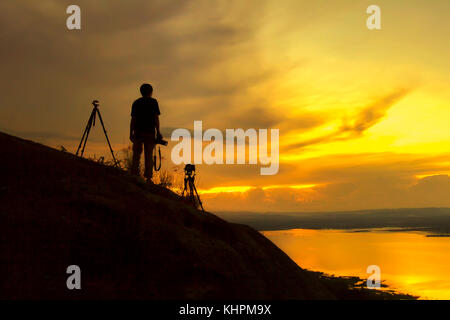 Silhouette fotografo di montagna riprese di attendere il Tramonto Tramonto di bellezza,prendendo foto fotografo con il tramonto del sole Foto Stock