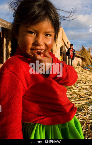 Isola di Uros, lago Titicaca, perù, Sud America. Una ragazza aymara vestita con costumi tipici della zona, composta da un'intensa gonna verde e da un colle Foto Stock