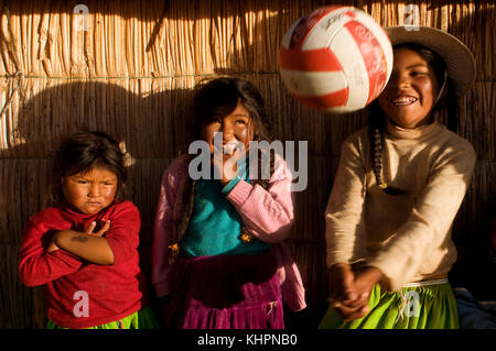 Isola di Uros, lago Titicaca, perù, Sud America. Alcune ragazze sull'isola di Los Uros, situate all'interno del lago Titicaca, giocano a pallavolo. Foto Stock